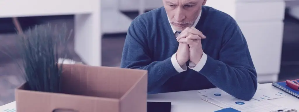 Man packing up his desk after being laid off